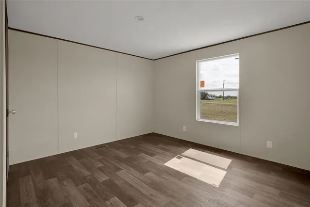 an empty room with windows and refrigerator