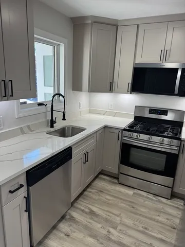 a kitchen with stainless steel appliances a stove a sink and a microwave