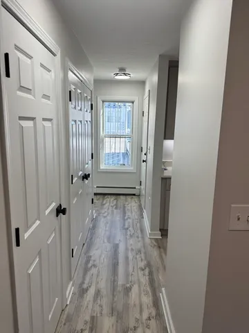 a view of a hallway with wooden floor and staircase
