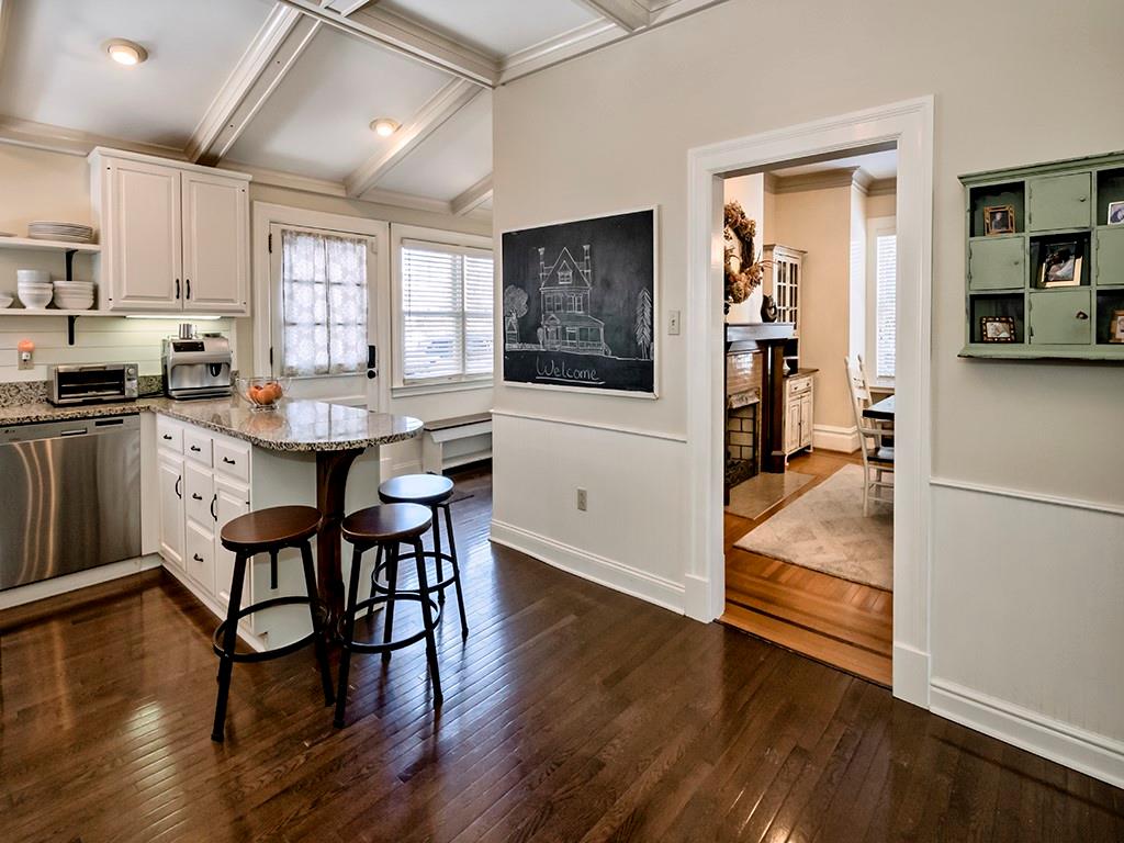 606 Bower Hill Road Pittsburgh, PA 15243 - Photo 11 of 24 a kitchen with stainless steel appliances granite countertop a stove a refrigerator a microwave a dining table and chairs with wooden floor