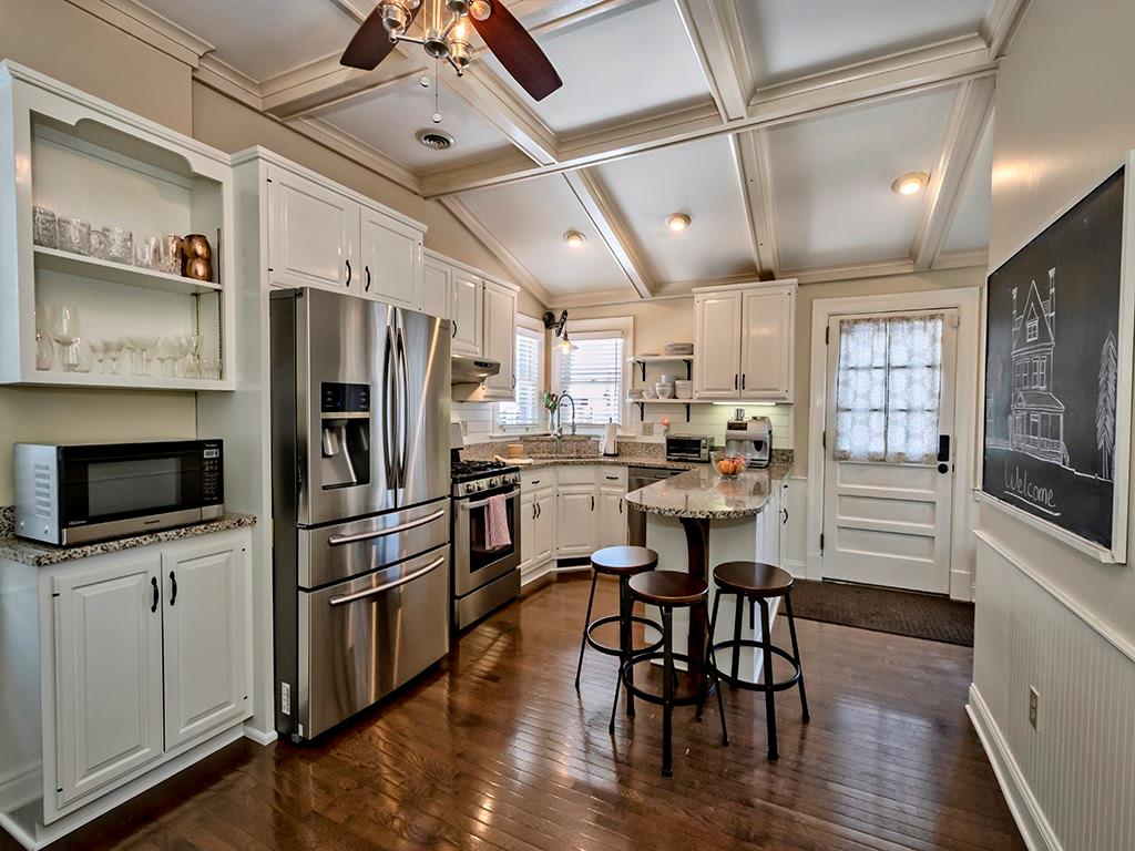 606 Bower Hill Road Pittsburgh, PA 15243 - Photo 9 of 24 a kitchen with stainless steel appliances granite countertop a stove a refrigerator a microwave oven a dining table and chairs with wooden floor