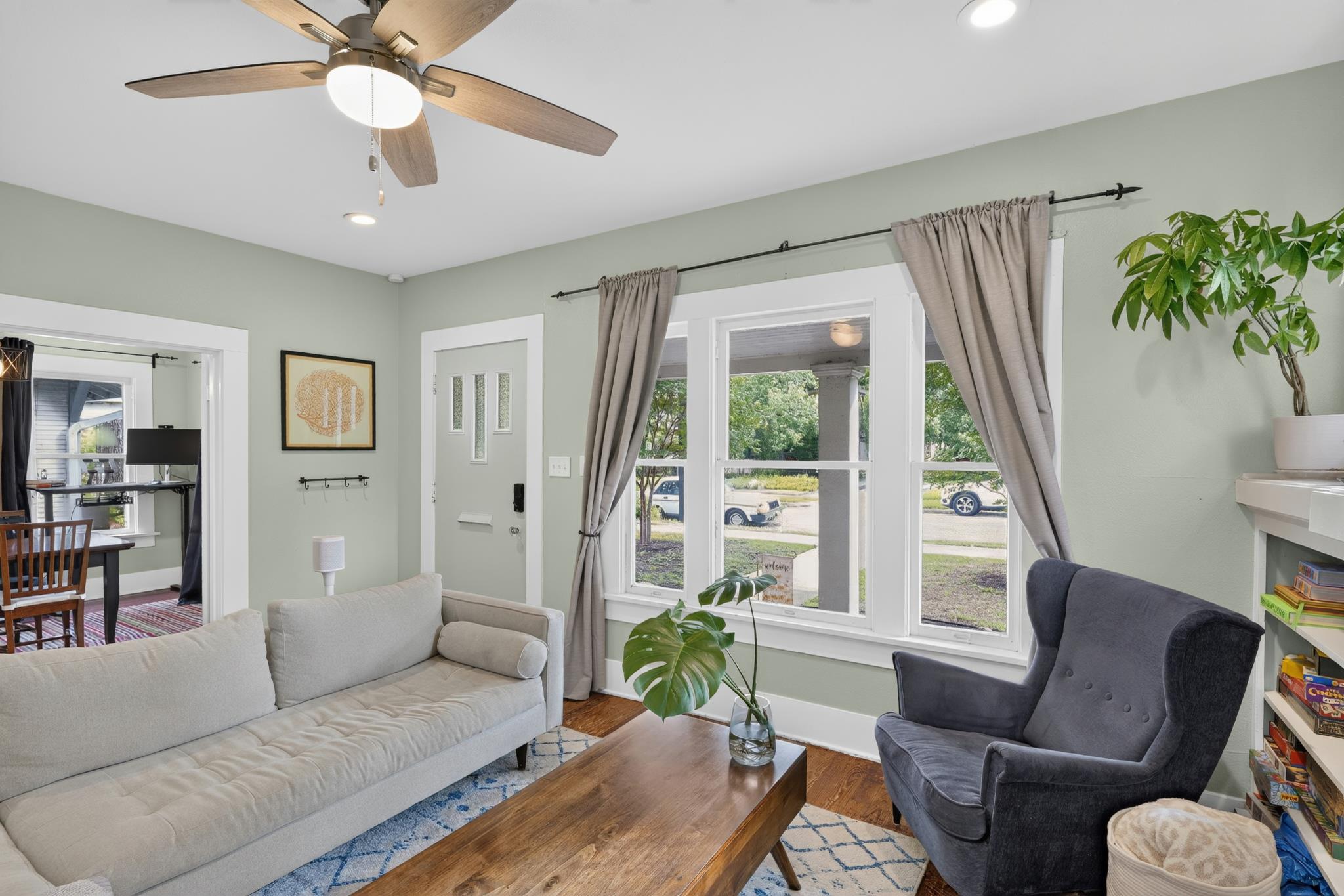 307 East 35th Street, Unit A Austin, TX 78705 - Photo 18 of 40 A comforting living space features a ceiling fan, abundant natural light, and hardwood flooring.