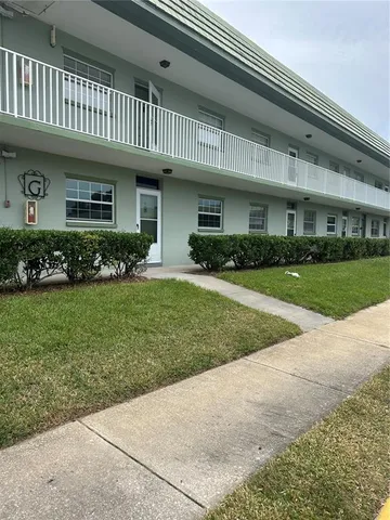 a front view of a house with a garden and plants