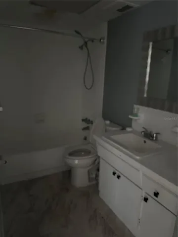 a bathroom with a granite countertop sink a toilet and shower