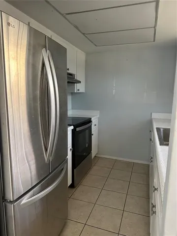 a kitchen with a refrigerator sink and cabinets
