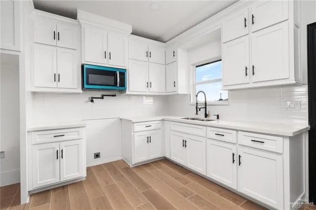 a kitchen with white cabinets stainless steel appliances and sink