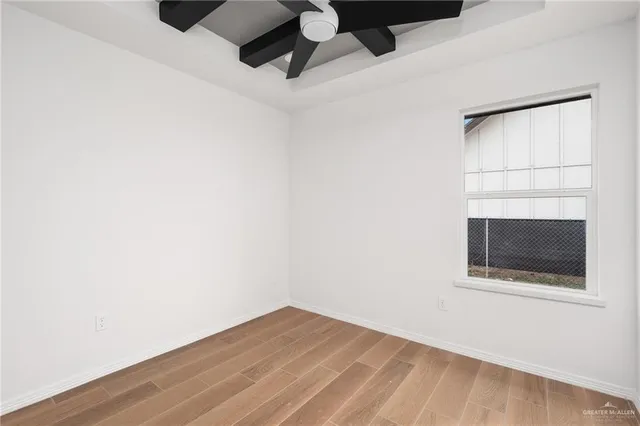 a view of a room with wooden floor and a ceiling fan