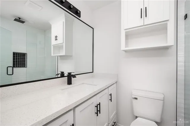 a bathroom with a sink a toilet and mirror