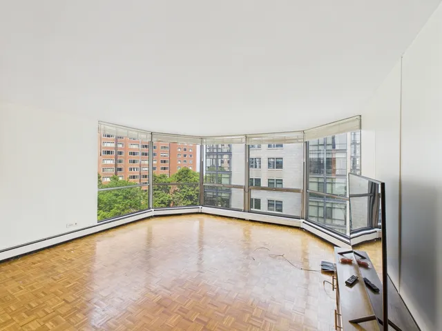a view of an empty room with a floor to ceiling window and pool view