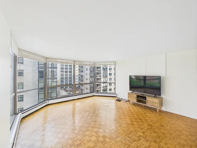 a view of an empty room with a fireplace and a flat screen tv