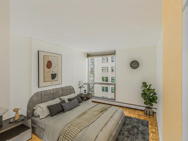 a bedroom with a bed and a potted plant