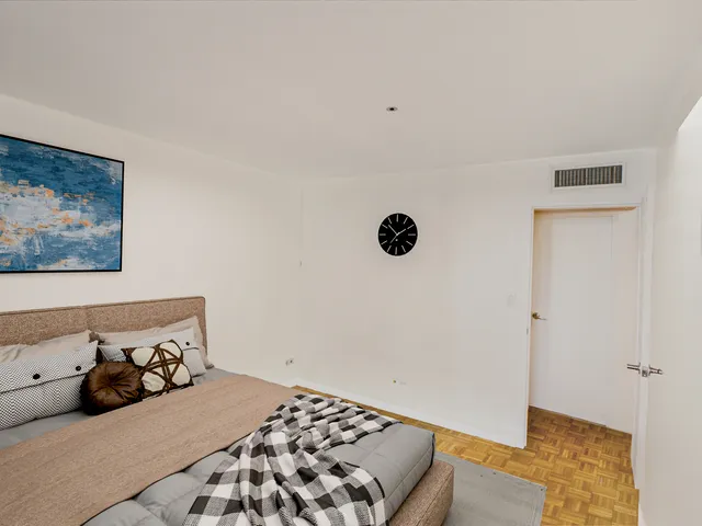 a bedroom with a bed and a painting on the wall