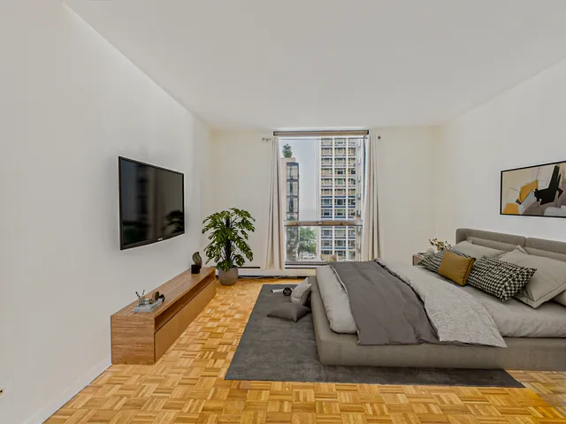 a spacious bedroom with a bed and a flat screen tv