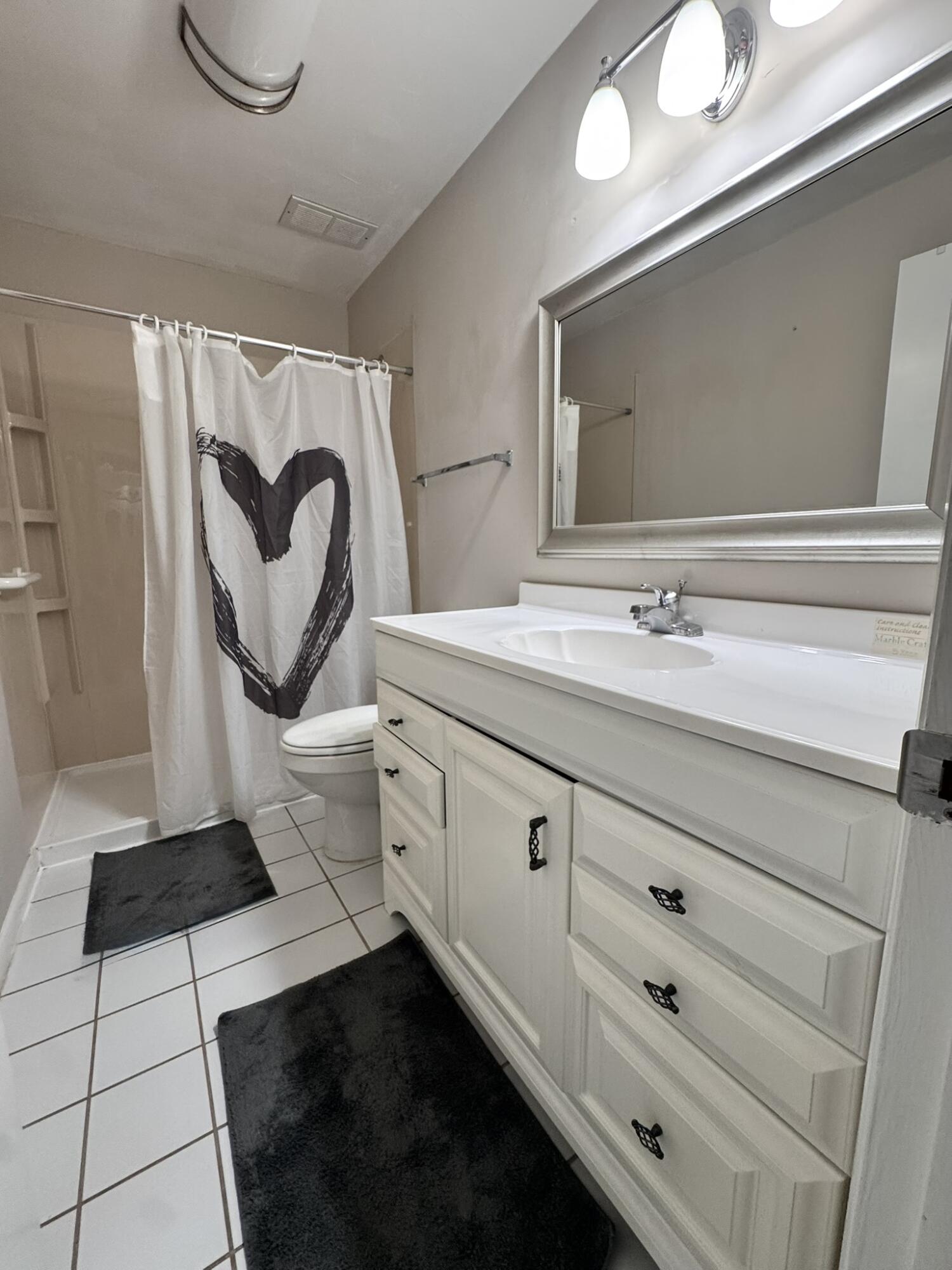 3124 Highway 441, Unit J1 Okeechobee, FL 34974 - Photo 13 of 40 a spacious bathroom with a sink and a mirror