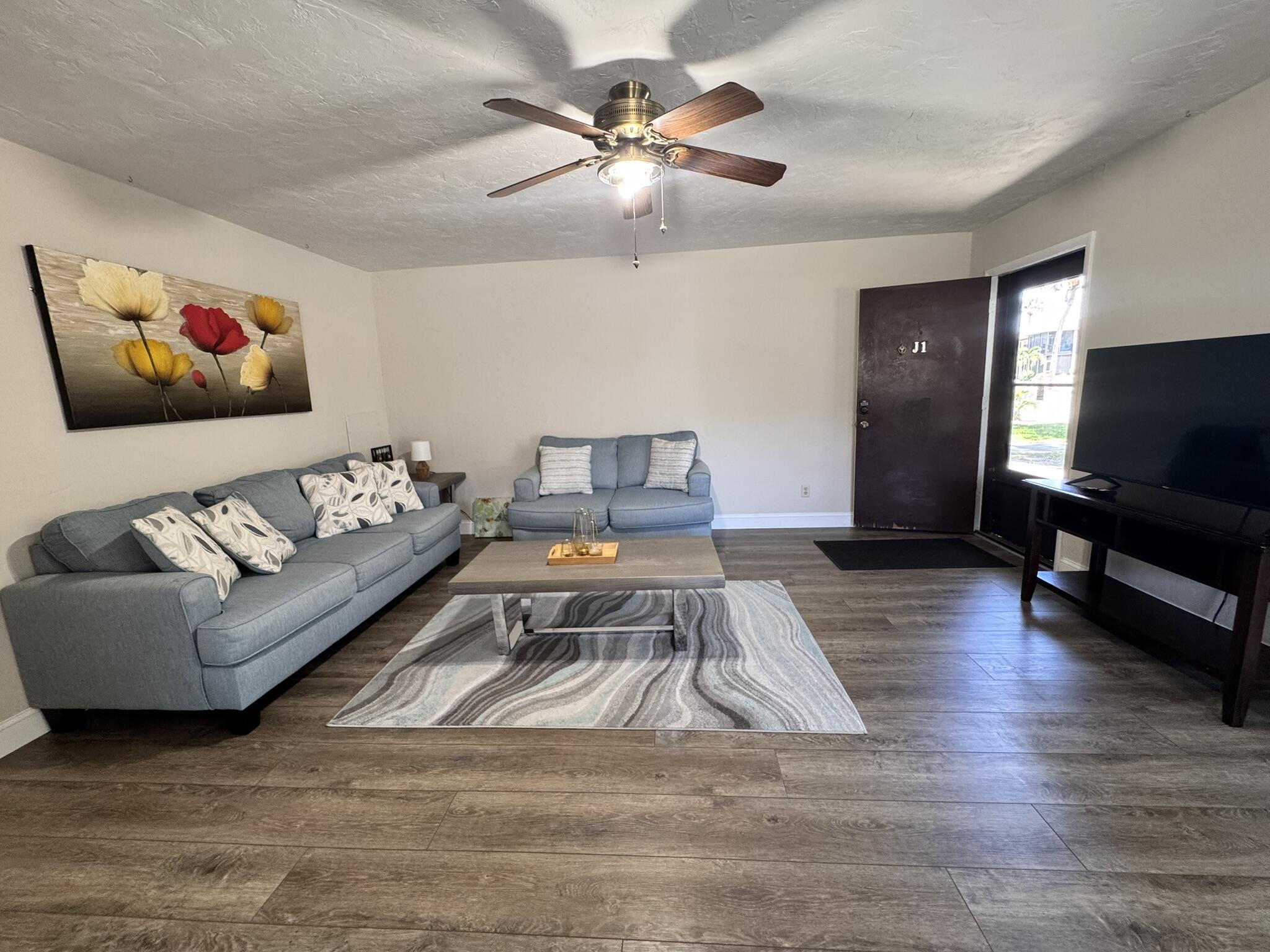 3124 Highway 441, Unit J1 Okeechobee, FL 34974 - Photo 9 of 40 a living room with furniture and a flat screen tv