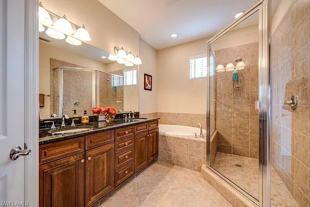 a bathroom with a double vanity sink a large mirror and shower