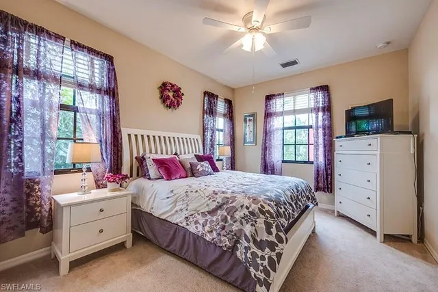 a bedroom with a large bed and a flat tv screen on dresser