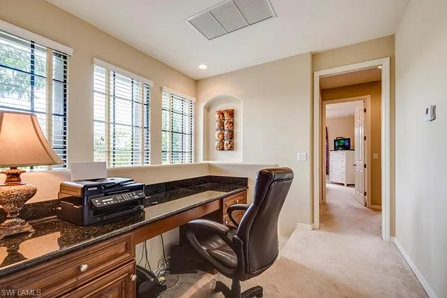 a view of a workspace with furniture and a window