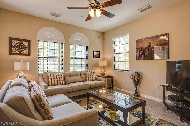 a living room with furniture a chandelier and a window
