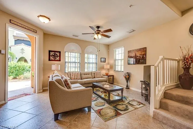 a living room with furniture ceiling fan and a window