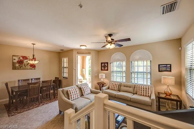 a living room with furniture a chandelier and a window