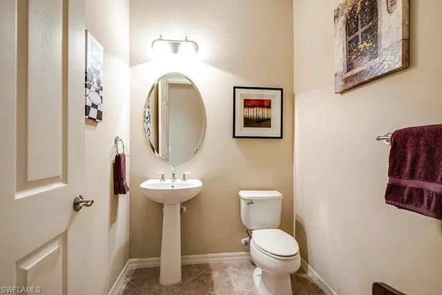 a bathroom with a toilet sink and mirror