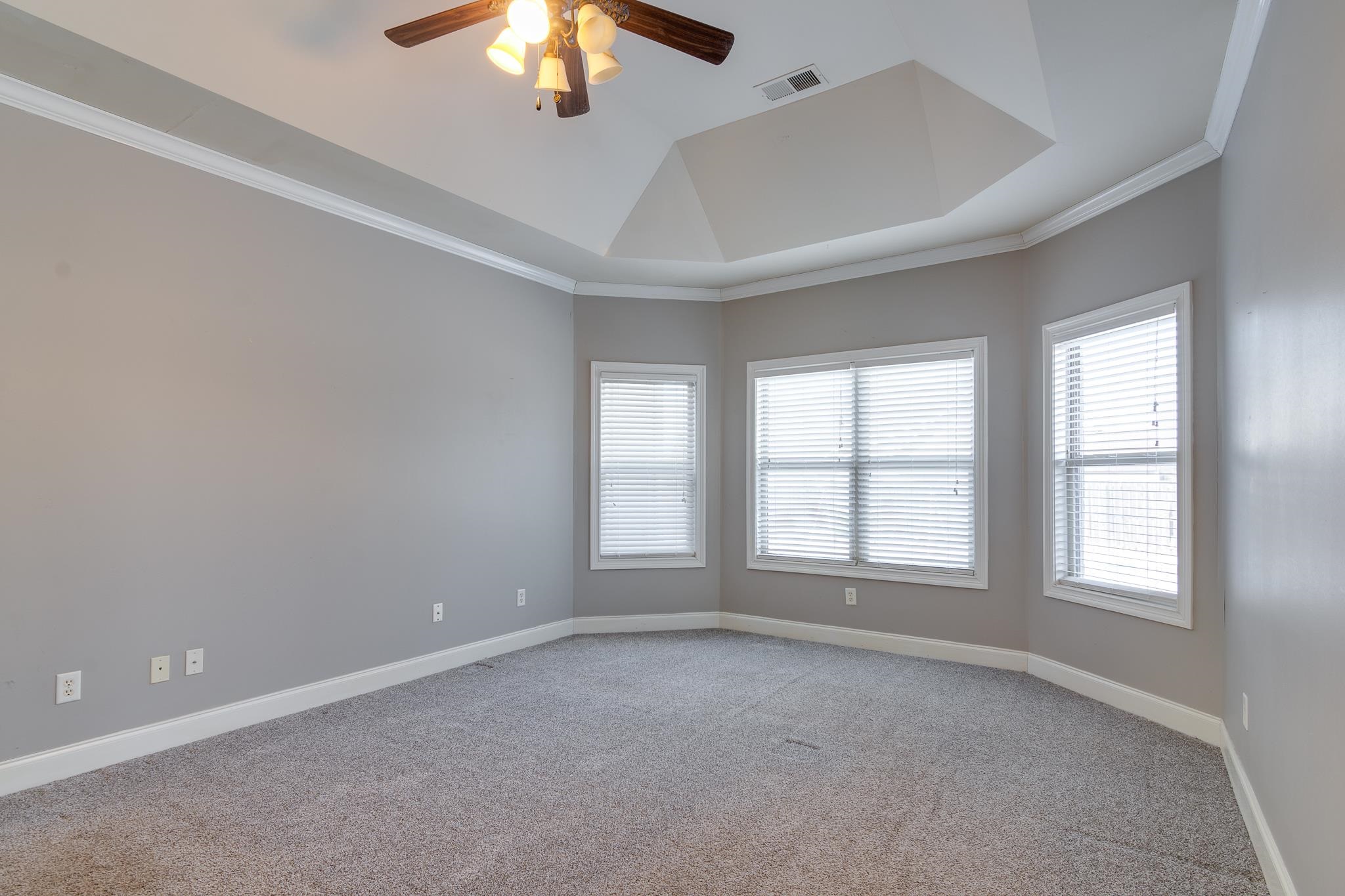 43 Tipton Rdg Cove Munford, TN 38058 - Photo 18 of 30 Carpeted bedroom with a ceiling fan, crown molding, and a tray ceiling