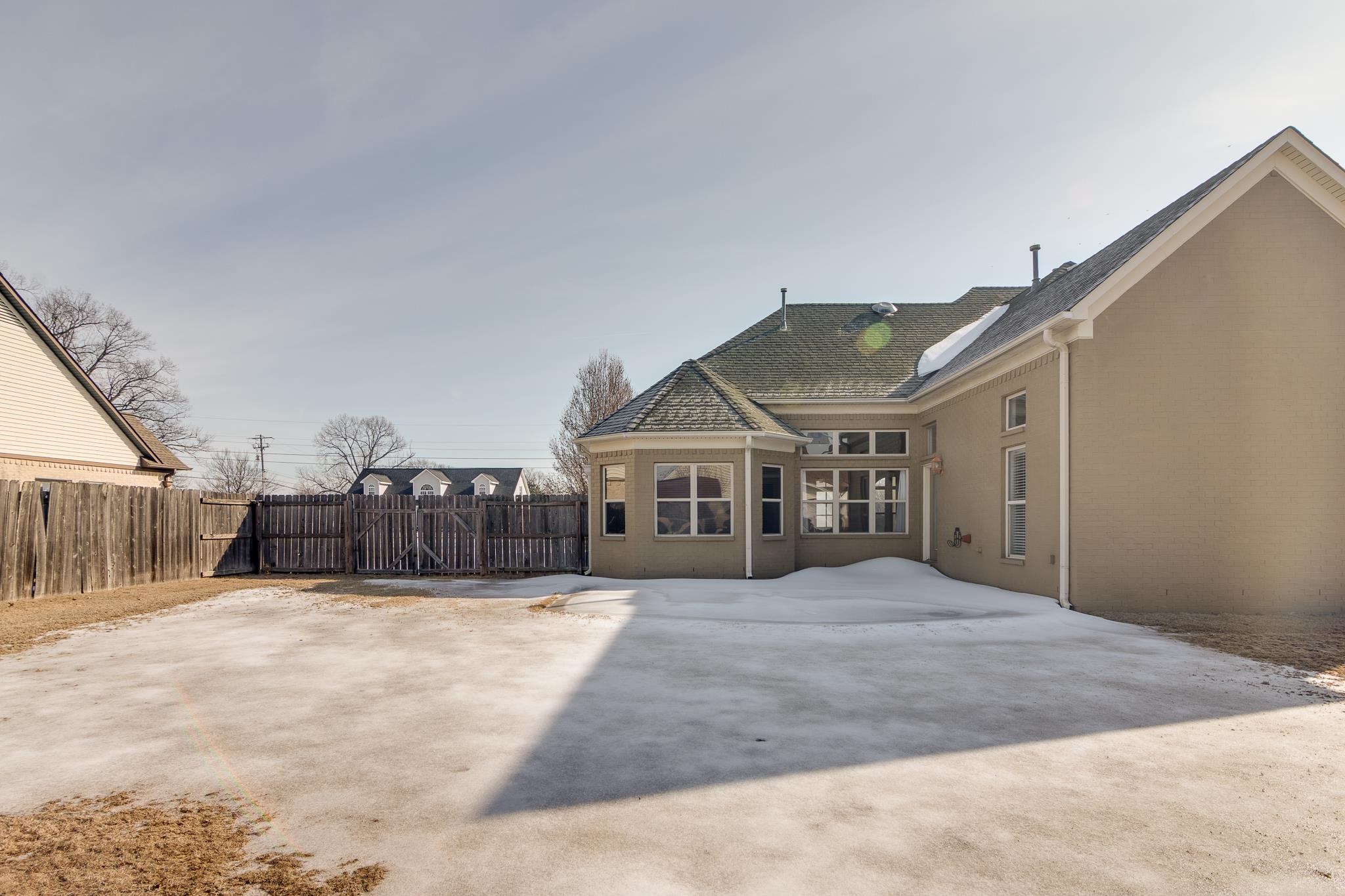 43 Tipton Rdg Cove Munford, TN 38058 - Photo 28 of 30 Back of property featuring a fenced backyard, a shingled roof, and stucco siding