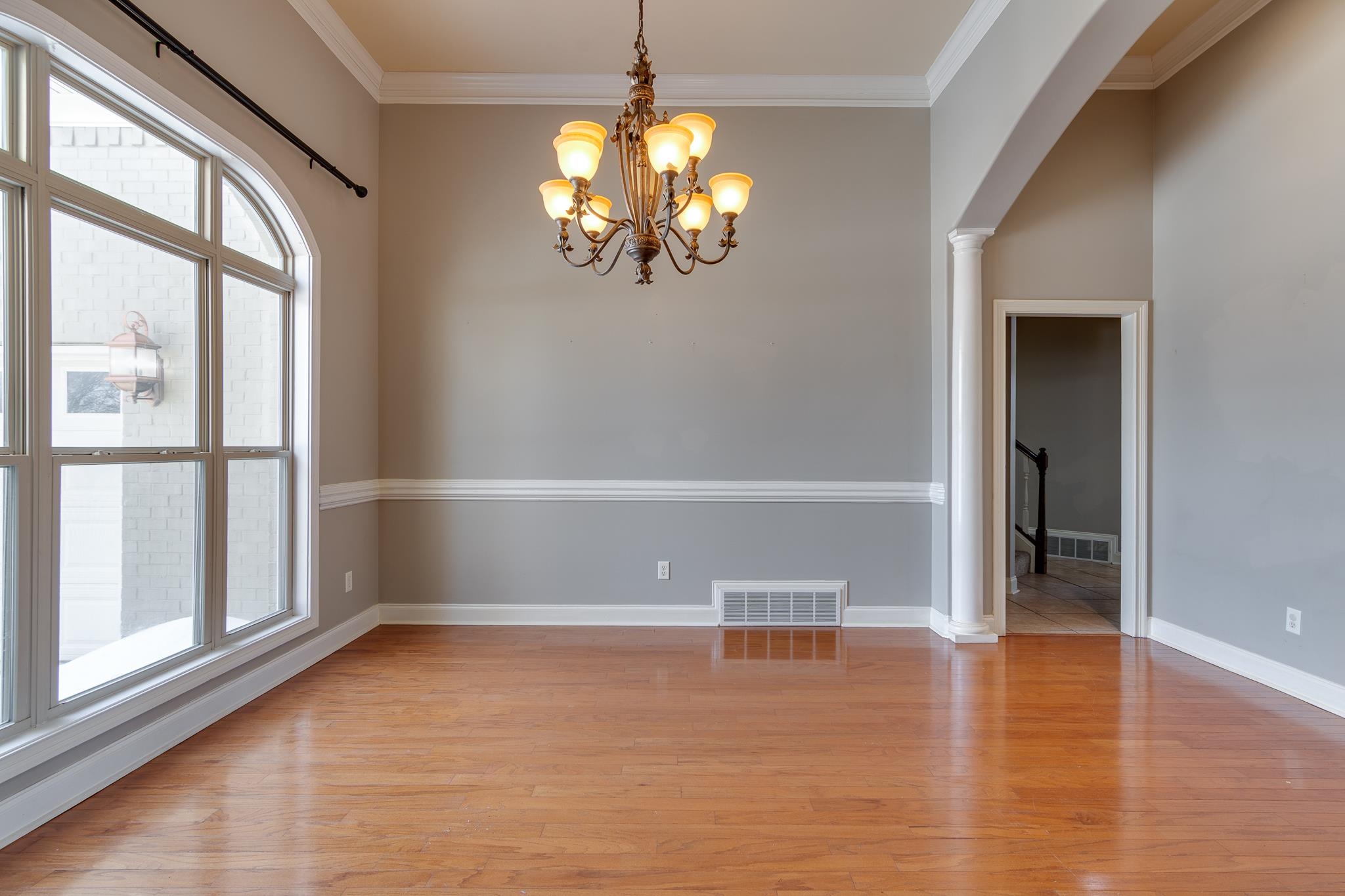 43 Tipton Rdg Cove Munford, TN 38058 - Photo 3 of 30 Dining room with arched walkways, crown molding, light wood-style floors, a chandelier, and ornate columns