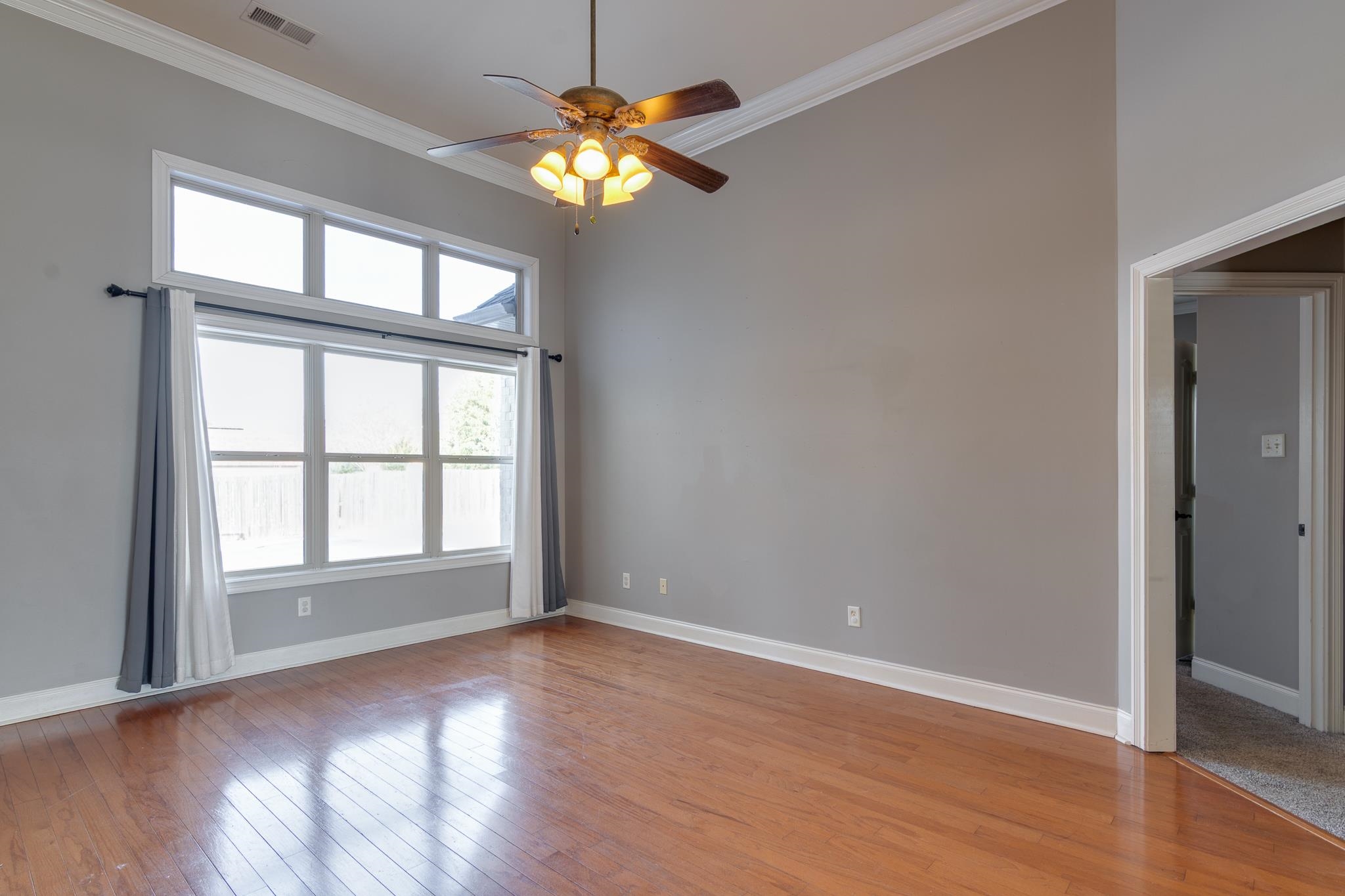 43 Tipton Rdg Cove Munford, TN 38058 - Photo 4 of 30 Family room featuring a ceiling fan, light wood finished floors, crown molding, and a high ceiling