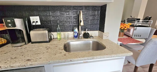 a bathroom with a granite countertop sink a mirror and vanity