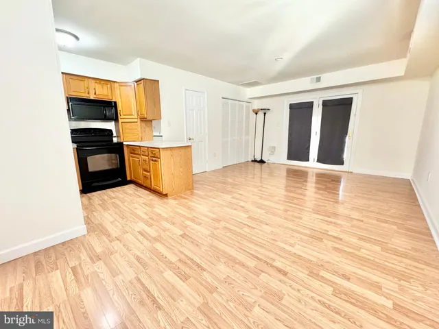 a view of a kitchen with wooden floor and stainless steel appliances