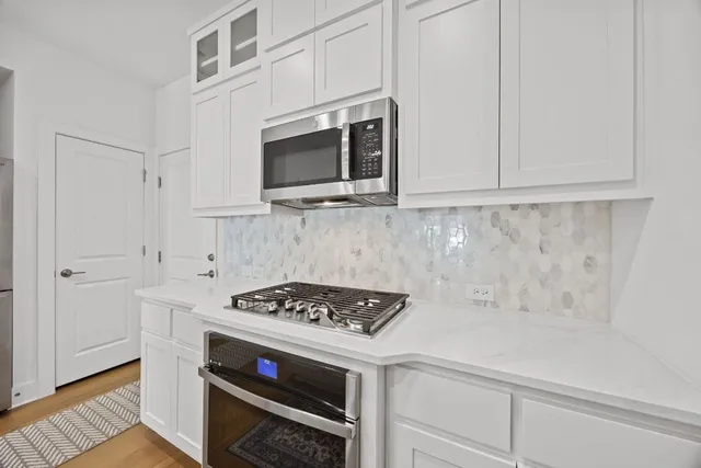 a kitchen with stainless steel appliances a stove a microwave and cabinets