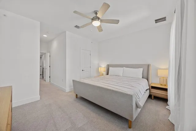 a bedroom with a bed and a ceiling fan