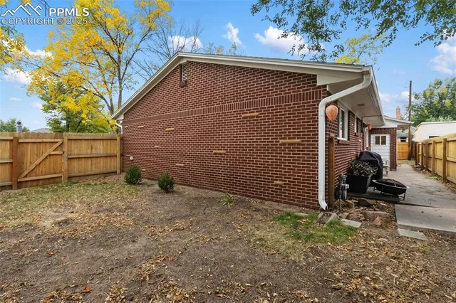a view of backyard with wooden fence