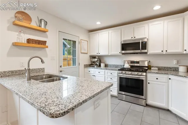 a kitchen with granite countertop a sink a stove and microwave
