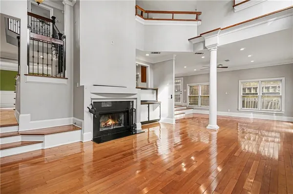 a view of a livingroom with wooden floor and a fireplace
