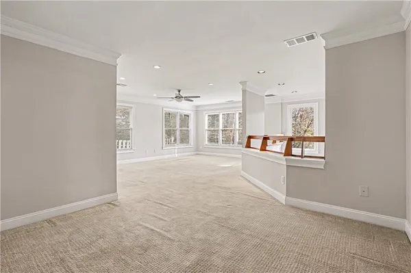 an empty room with windows and kitchen view