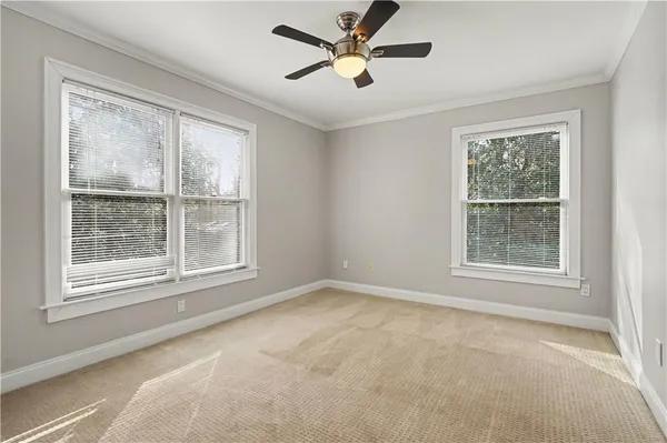 a view of an empty room with a window and a ceiling fan