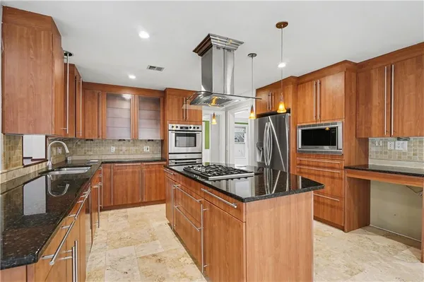 a kitchen with stainless steel appliances granite countertop a sink stove and refrigerator