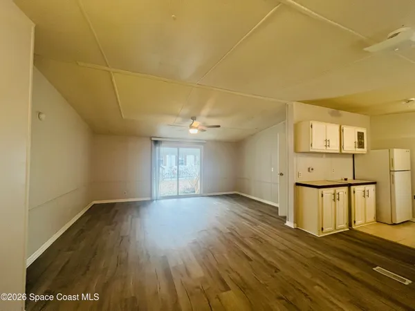 a view of a room with wooden floors and white walls