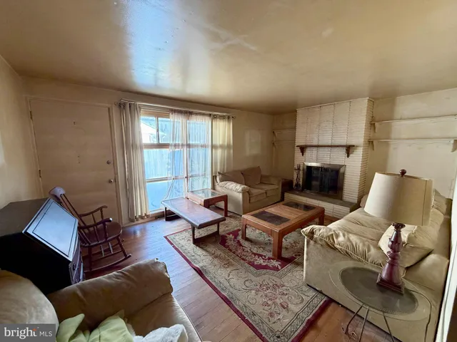 a living room with furniture wooden floor and a window
