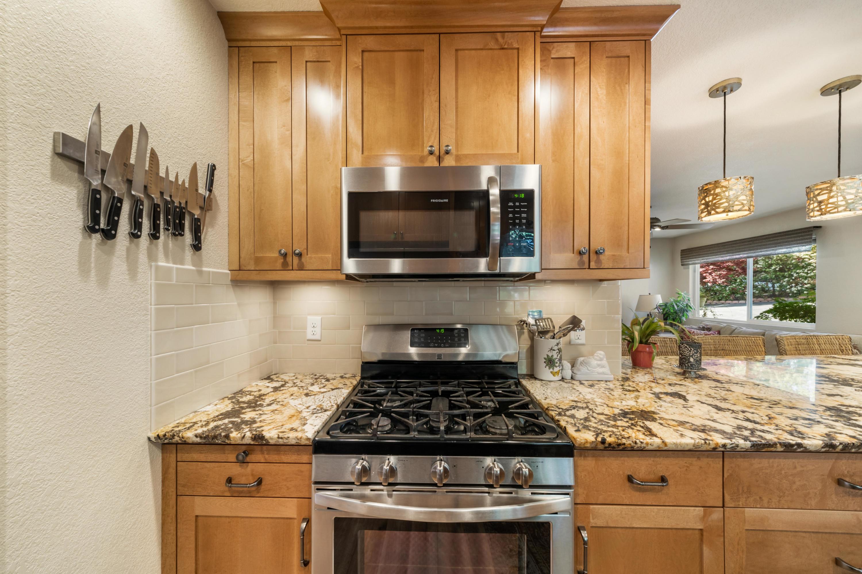 7777 Justice Mine Road Redding, CA 96001 - Photo 14 of 59 a kitchen with granite countertop a stove and a sink