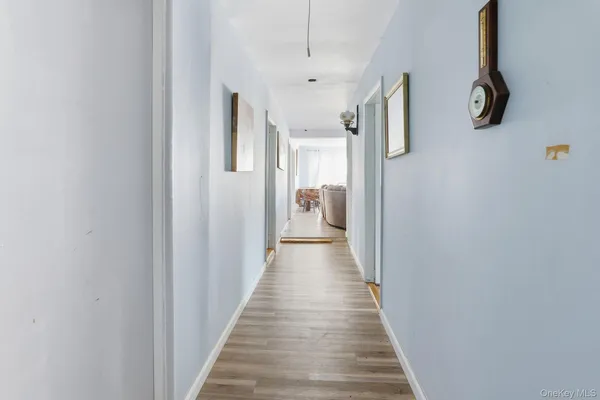 a view of a hallway with wooden floor and windows