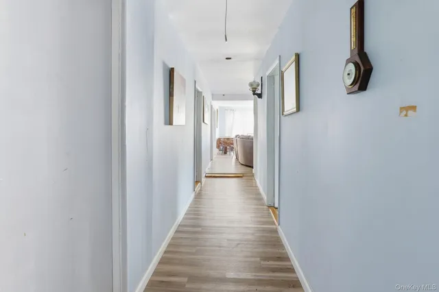a view of a hallway with wooden floor and windows