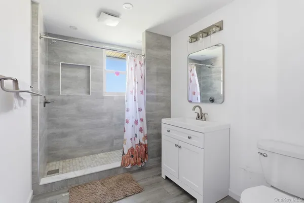 a bathroom with a sink a toilet and shower