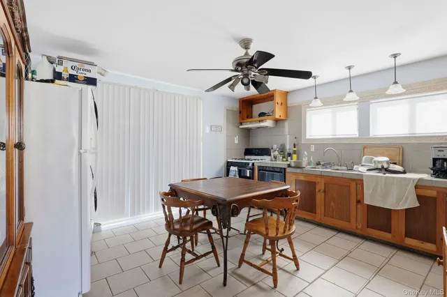 a kitchen with stainless steel appliances kitchen island a table and chairs in it