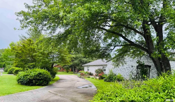 a front view of a house with a yard and tree