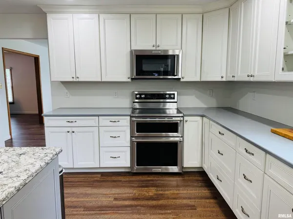 a kitchen with a sink cabinets and wooden floor