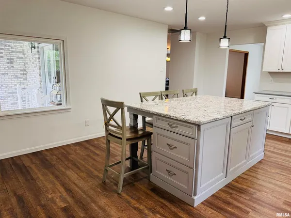 a kitchen with kitchen island a counter top space appliances and cabinets
